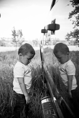 Little boy leaning against pickup truck