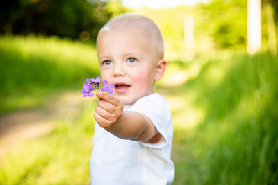 adorable boy holding out flowers